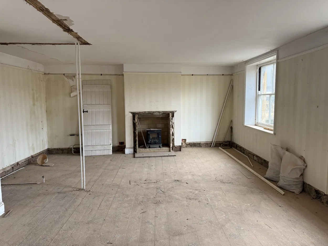 Sundial, as found: a panelled room with a fireplace