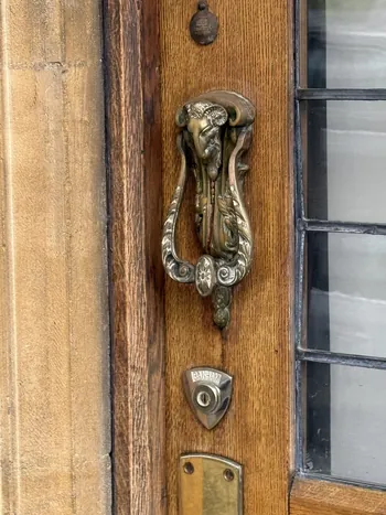 Sundial, a brass knocker on an oak door