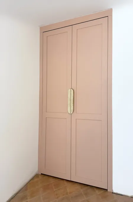 A Walk in the Park, the studio wardrobe, hand-painted in a soft, dusty pink, with a travertine handle