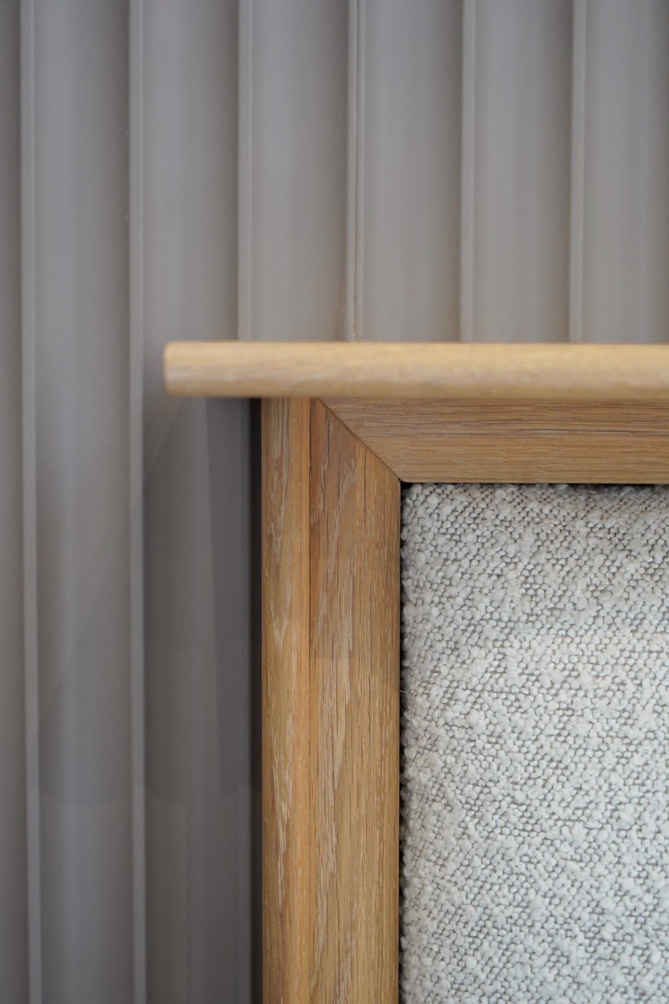 Suite Escape, detail, an oak corner against the fluting and bouclé